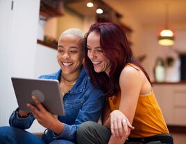 Couple smiling and using tablet computer