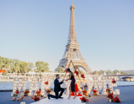 Man proposing to woman in Paris with a 'marry me' sign in front of the Eiffel Tower