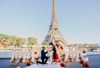 Man proposing to woman in Paris with a 'marry me' sign in front of the Eiffel Tower