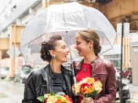 Brides on rainy wedding day under umbrella