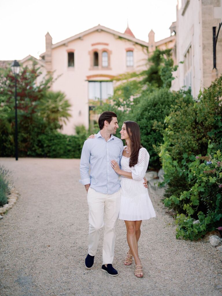 Couple walking in front of historic French building romantic summer engagement photo idea
