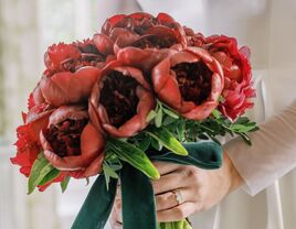 winter wedding bouquet with red peonies, greenery and green velvet ribbons