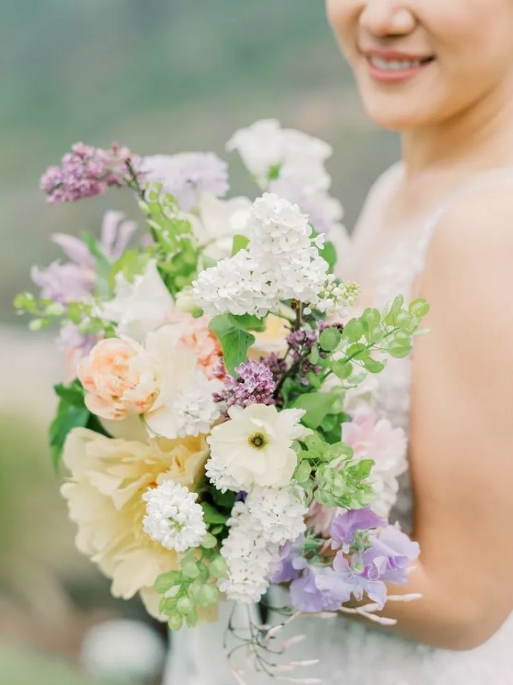bride holding purple-and-white lilac bouquet