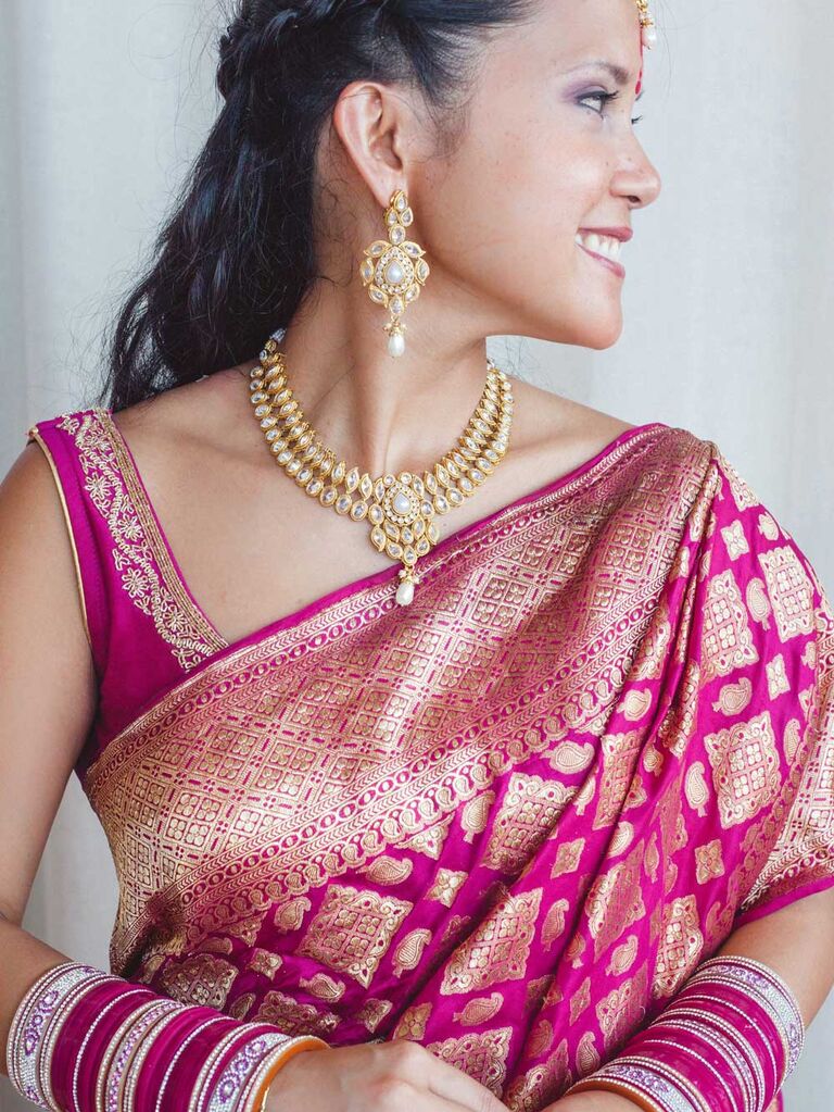 Bride wearing maroon and gold lehenga and saree