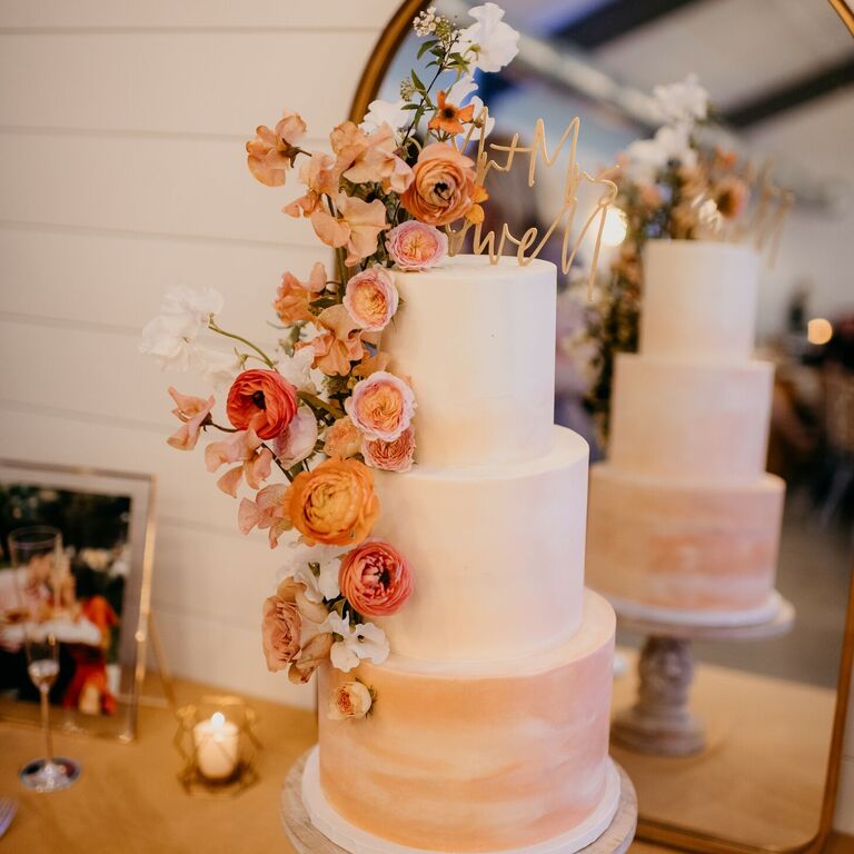Three-tier orange ombre wedding cake with orange flowers