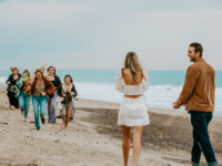 Couple surprised with friends after proposal on beach