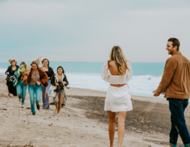 Couple surprised with friends after proposal on beach