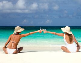 best friends toasting with drinks in the Caribbean