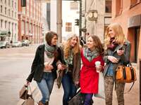 four women walking arm in arm in downtown denver