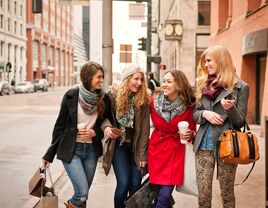 four women walking arm in arm in downtown denver