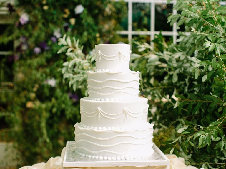 four tier smooth buttercream wedding cake decorated with hand piped scallops