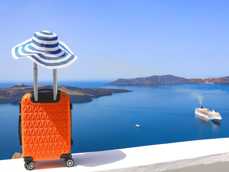 A suitcase and blue striped hat with islands in the background