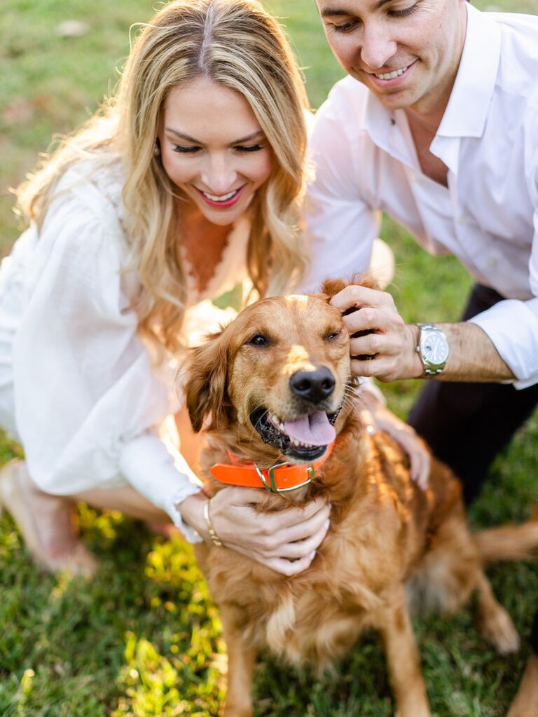 Couple pose with their dog. 