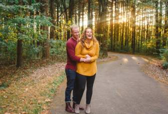 Couple hugging and smiling in woods in Ohio during fall