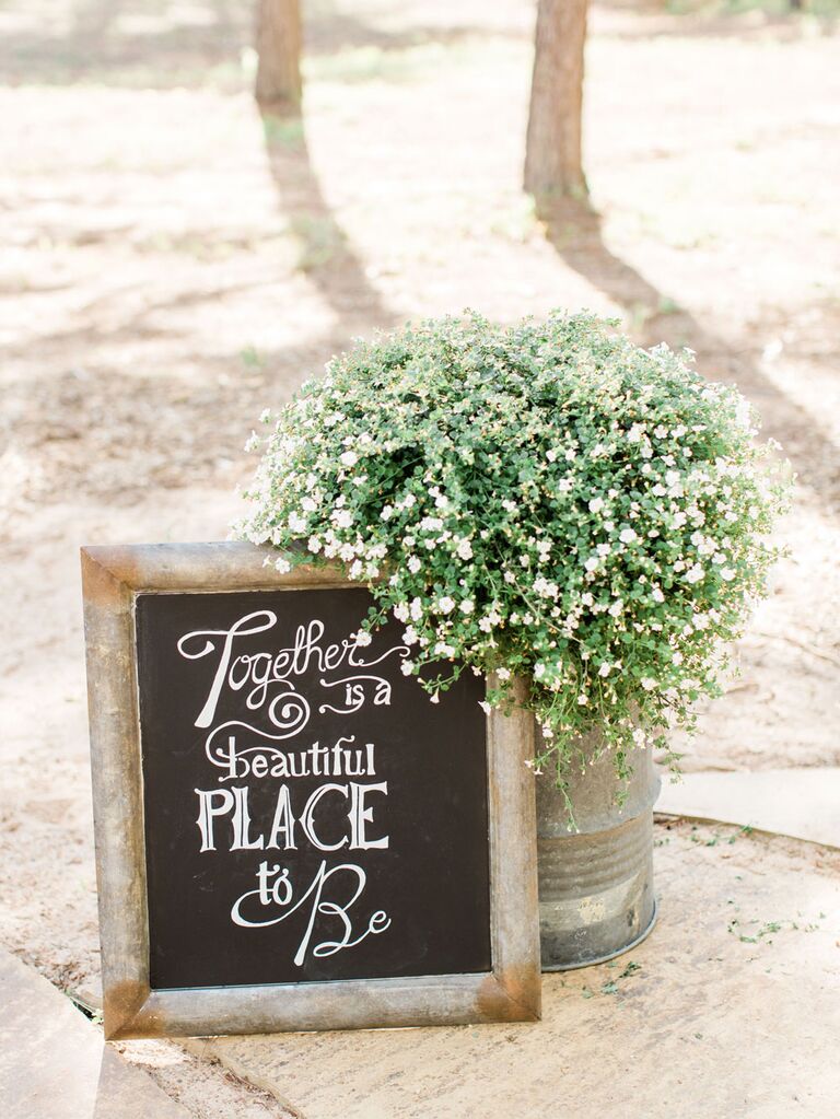 Rustic wedding chalkboard sign decoration next to potted baby's breath