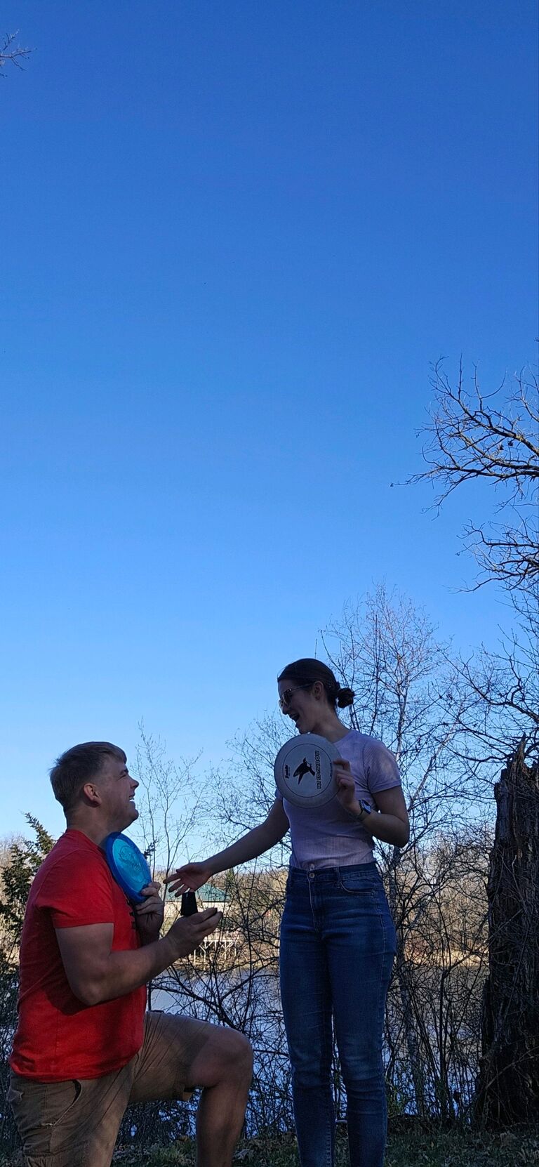 Robert suggested they go frisbee golfing after a weekend in the cities with Cassandra's family. Robert surprised Cassandra by setting his phone up to take a timed photo and proposed!