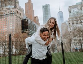 Happy couple messing around in a park and posing for a picture