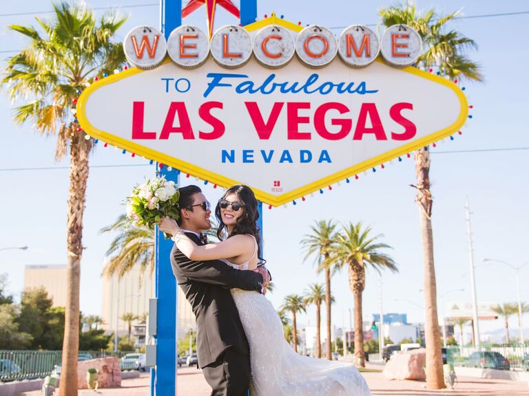 Newlyweds in front of Vegas sign in Las Vegas, Nevada