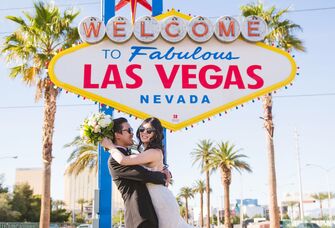 Newlyweds in front of Vegas sign in Las Vegas, Nevada