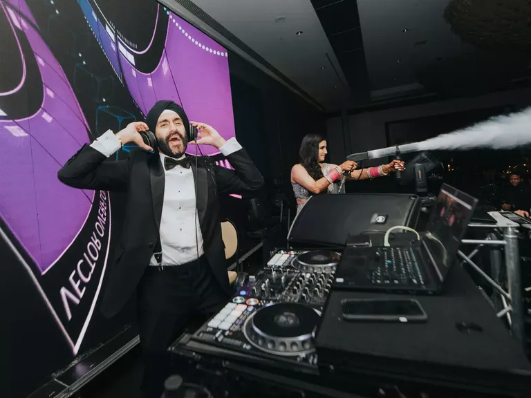Groom in a Black Tuxedo and Turban Plays DJ, Bride Shoots Smoke at Reception
