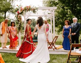 Couple holding hands and walking toward ceremony mandap