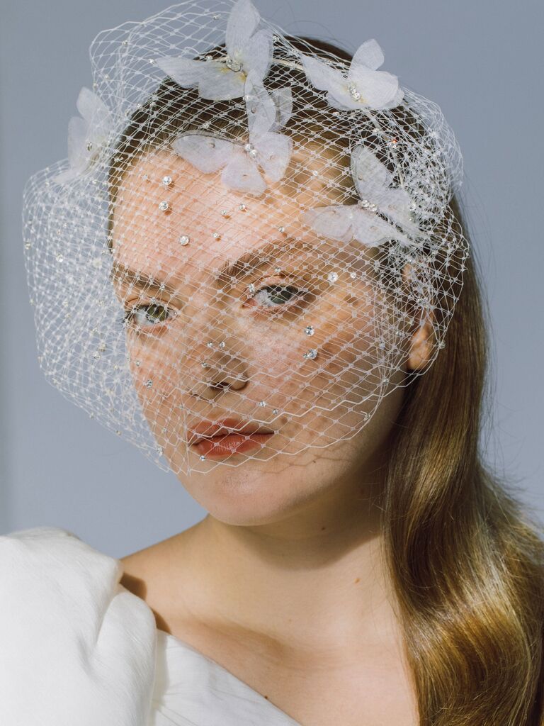 Model wears a stunning birdcage veil with butterfly embellishments. 