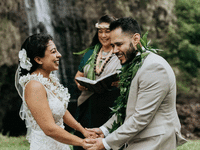 Couple getting married outside next to waterfall.