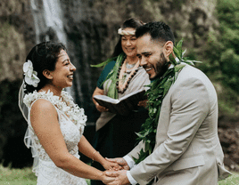 Couple getting married outside next to waterfall.