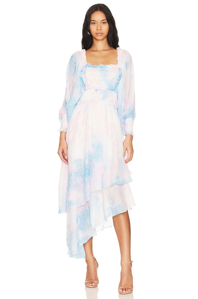Model wears a pastel patterned gown. 