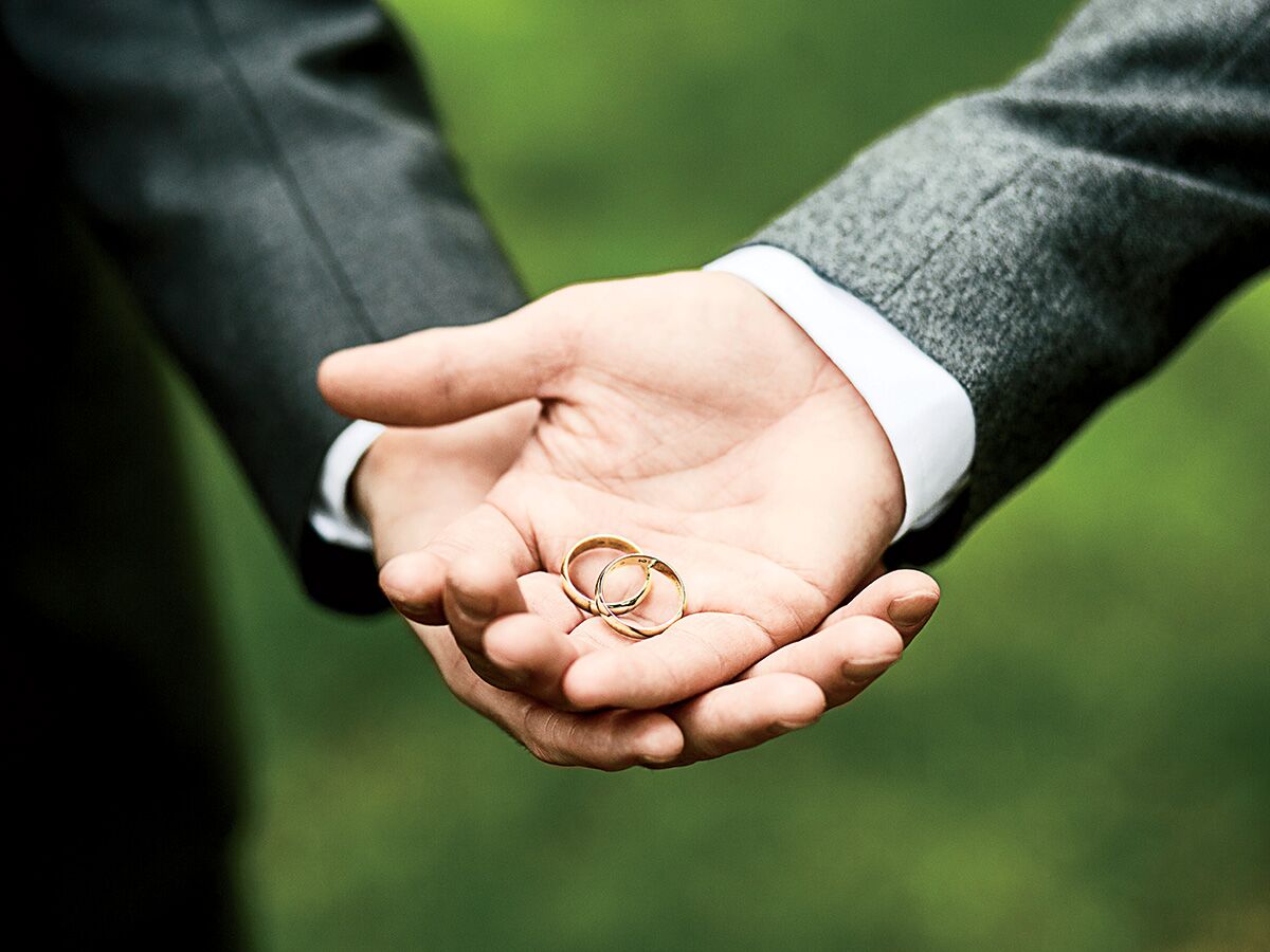LGBTQ+ couples holding their wedding rings