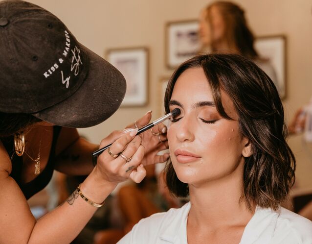 Bride gets her makeup done by a professional makeup artist. 