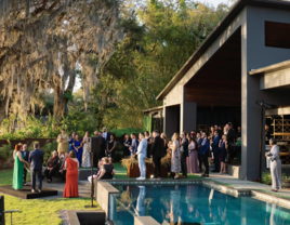 Wedding guests gathered in backyard wedding venue with pool