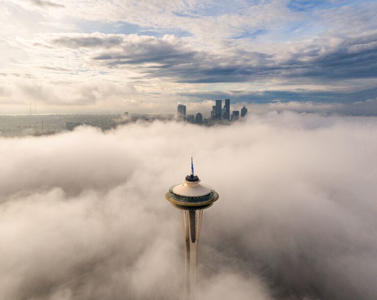 seattle skyline rises above clouds and the atmosphere in a dramatic fashion 