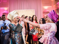 A bride and her wedding guest dance the night away in traditional Yoruba attire.