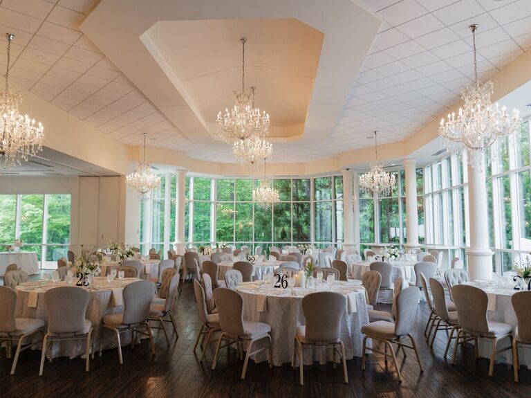Inside the glamourous wedding reception space with hanging chandeliers