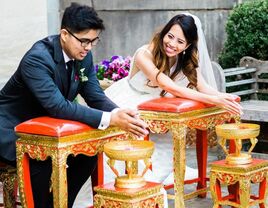 Couple smiling at each other during traditional Thai water blessing ceremony