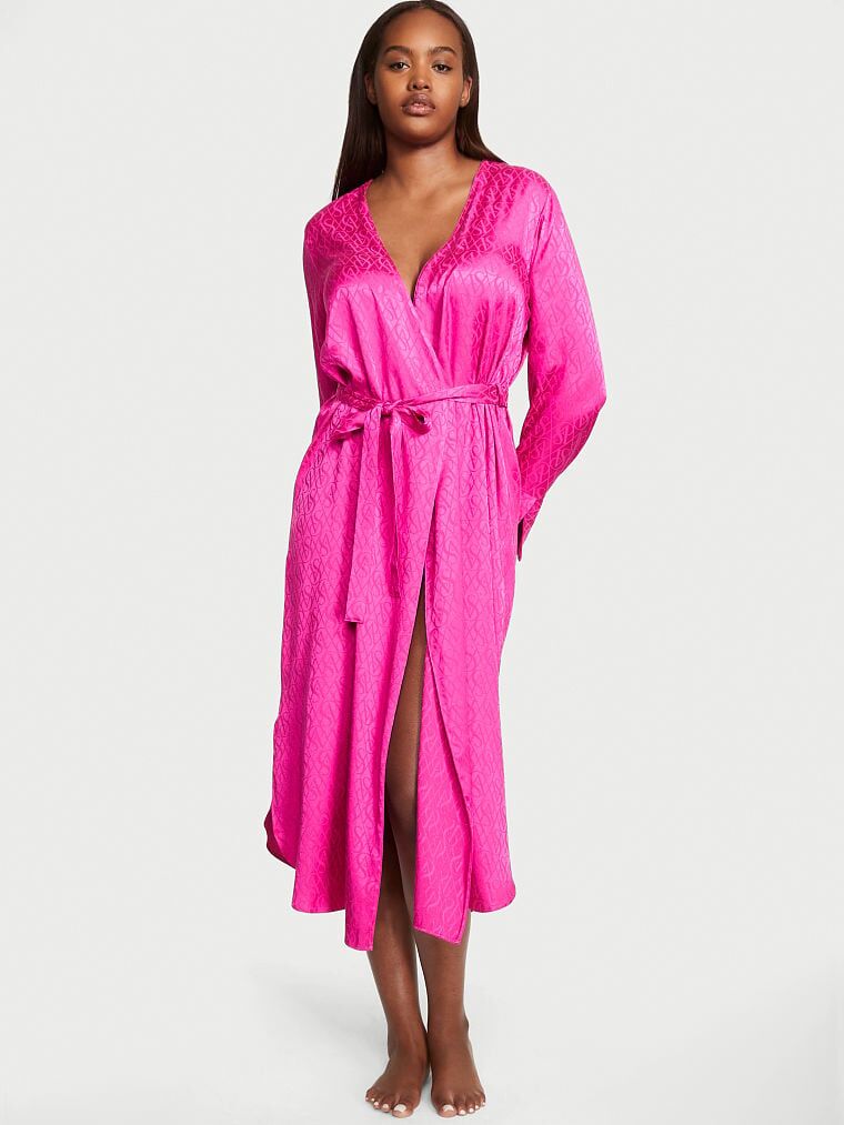 Model wearing a long-sleeve satin robe in pink with a matching waist tie