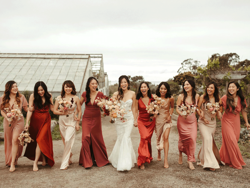 Bride and bridesmaids holding bouquets in front of their faces.