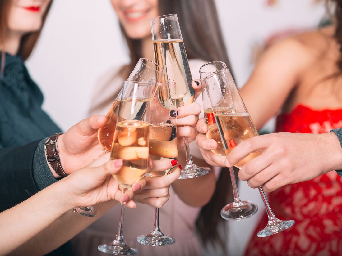 Bridesmaids and bride clinking champagne glasses at bachelorette party