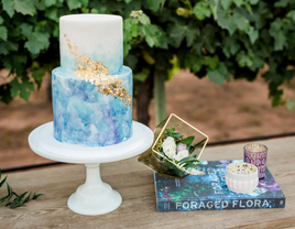 Blue watercolor two-tier wedding cake with gold leaf