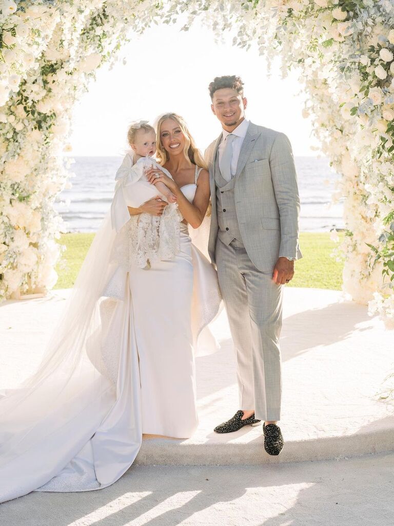 Brittany, Patrick, and their daughter pose for the camera on their wedding day. 