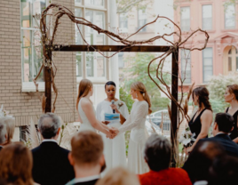 Couple holding hands while officiant does wedding reading