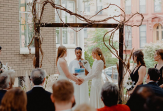 Couple holding hands while officiant does wedding reading