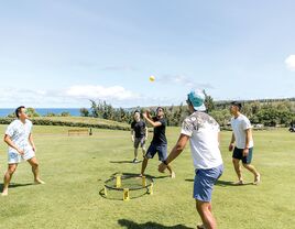 Group of men playing spikeball outside at bachelor party