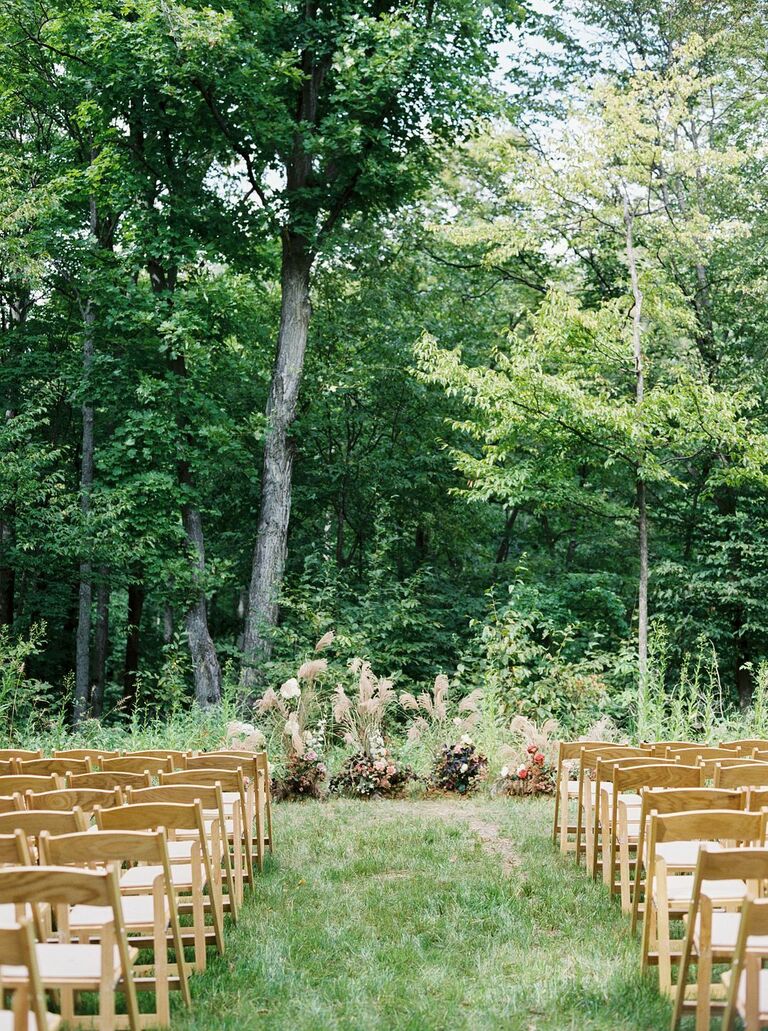 Outdoor wedding ceremony with light wood folding chairs