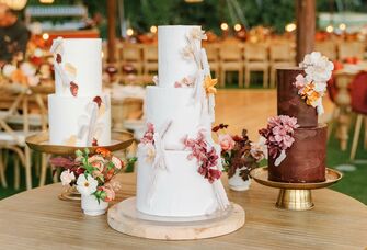 trio of wedding cakes on wooden table at reception