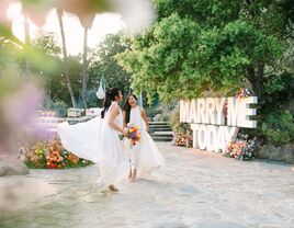 Two brides smiling and dancing on wedding day