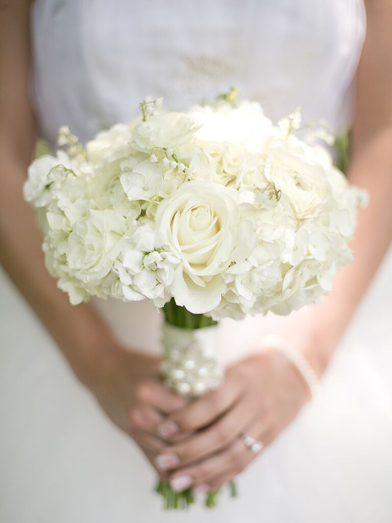 A classic white wedding bouquet with lily of the valley, hydrangea and roses