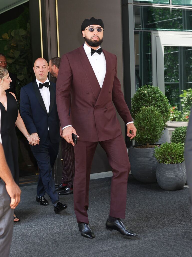 Travis Kelce's friend Ross Travis leaving hotel for the wedding in maroon suit