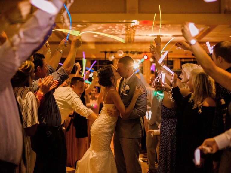 Couple kissing on the dance floor surrounded by guests